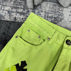 Neon lime green pants with front pockets, button fly, and cross applique embroidery