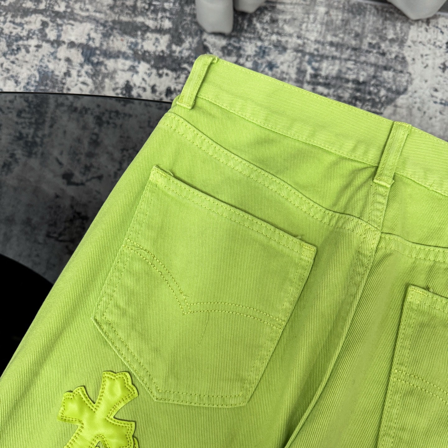 Lime green pants with wide waistband and front patch pockets; visible stitched panel detail