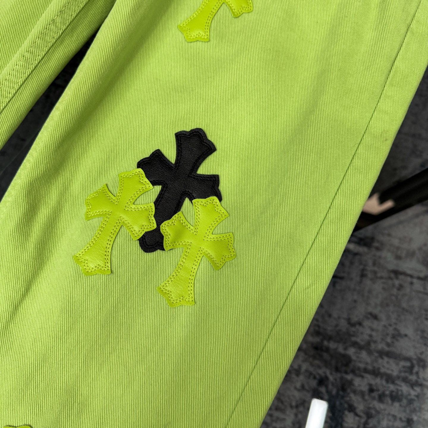 Neon lime green pants with bold black and light green cross patches on leg