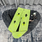 Neon lime green pants with black and green cross patches, button-front and pockets