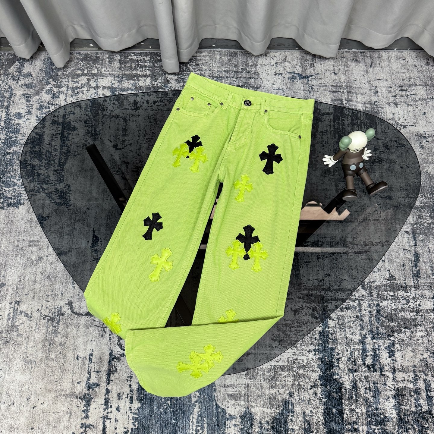 Neon lime green pants with black and green cross patches, button-front and pockets