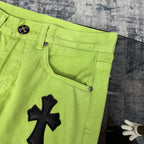 Neon lime green pants with curved front pocket opening, belt loops, and cross applique