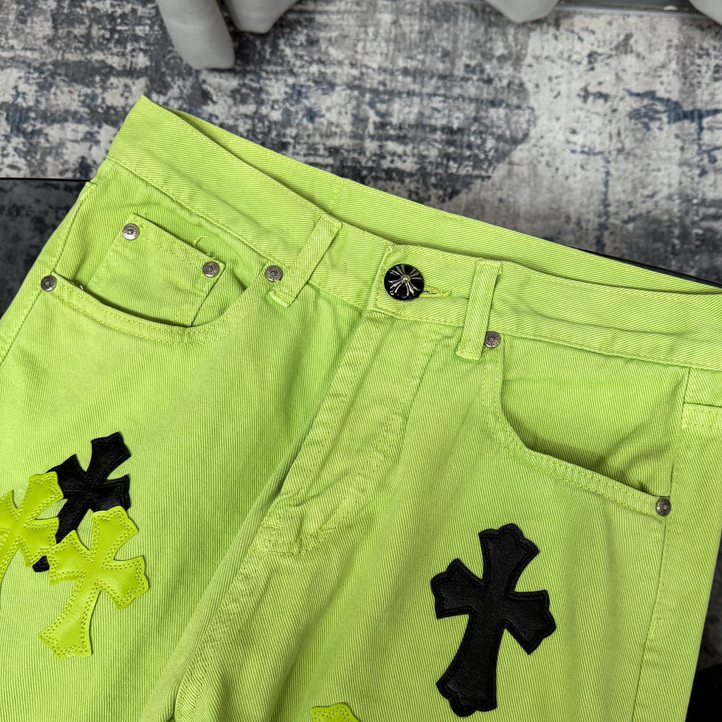 Neon lime green jeans with button waistband, belt loops, and cross applique detail