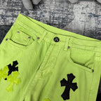 Neon lime green jeans with button waistband, belt loops, and cross applique detail