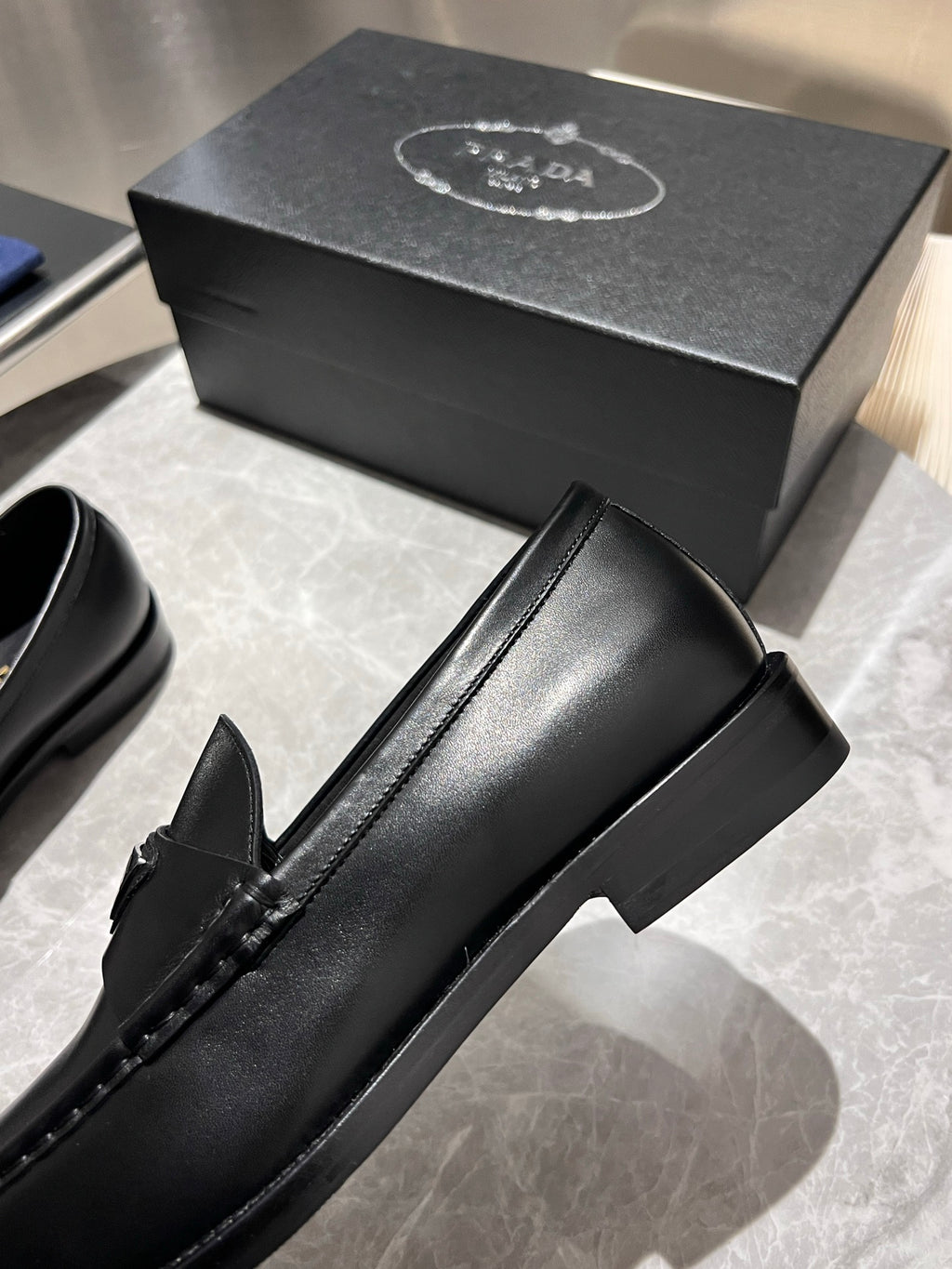 Black leather loafer with low-profile sole, Prada logo on strap