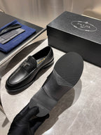 Black leather loafers with Prada logo, shown with matching shoe box
