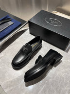 Black leather loafers with Prada logo, side view with visible stitching