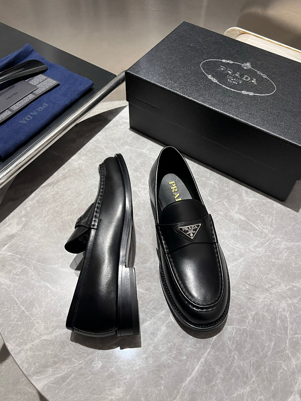 Black leather loafers with low stacked heel, Prada logo on vamp
