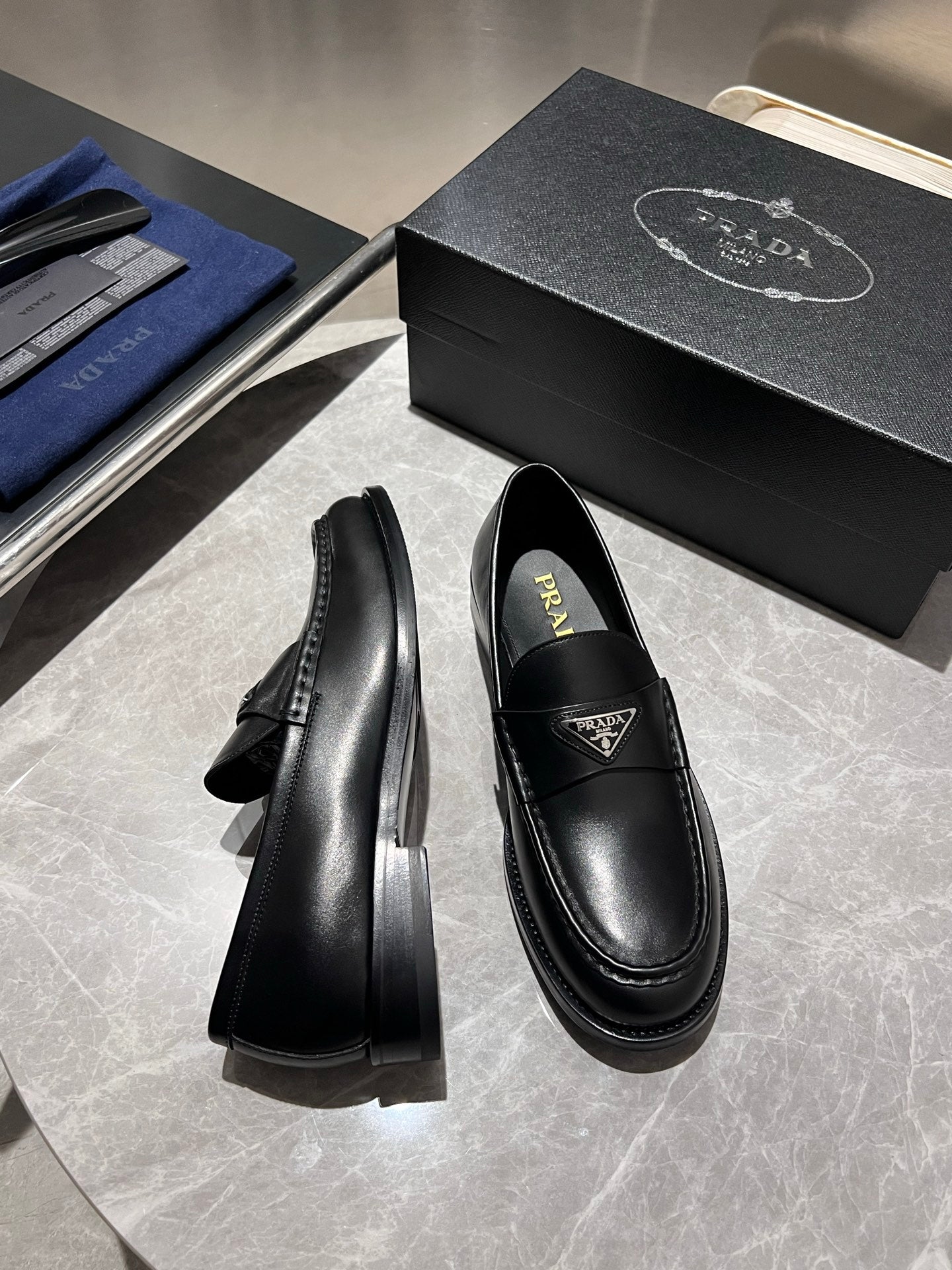 Black leather loafers with low stacked heel, Prada logo on vamp