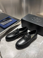 Black leather loafers pair, slip-on design with Prada logo emblem