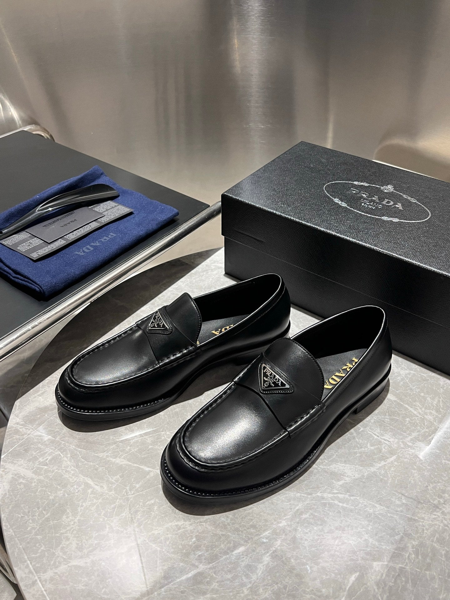 Black leather loafers pair, slip-on design with Prada logo emblem