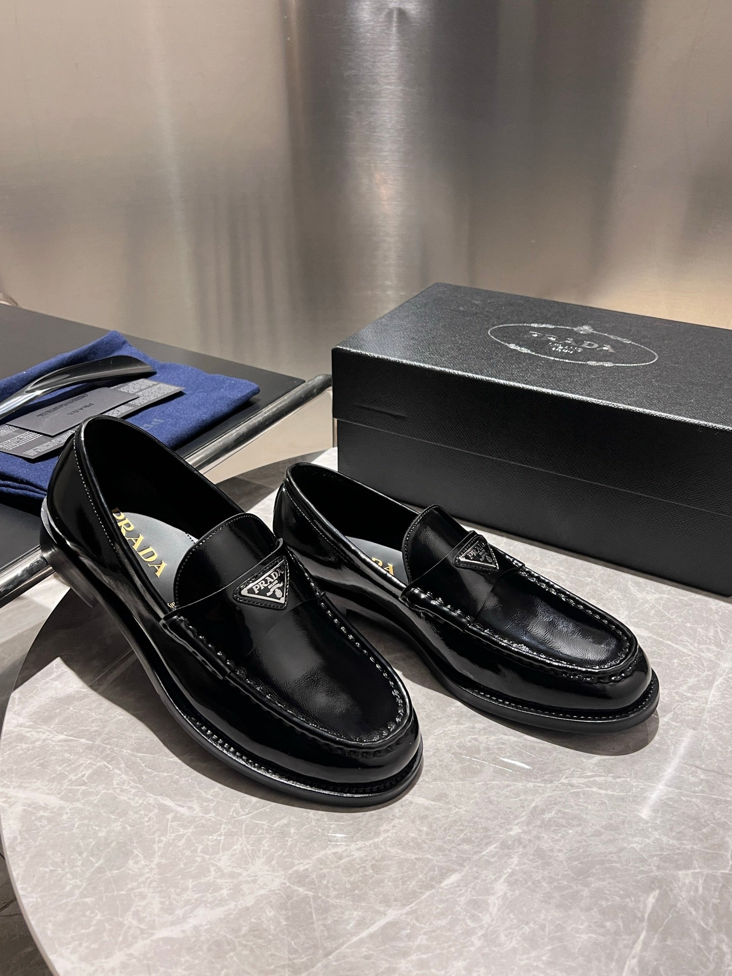 Prada unisex black patent loafers, side view with decorative stitching