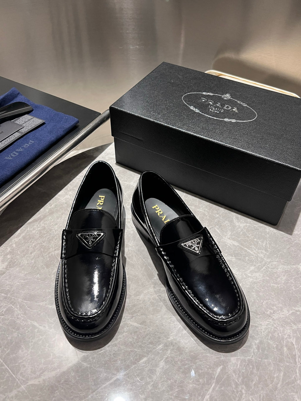 Prada unisex black patent loafers with Prada branding on insole