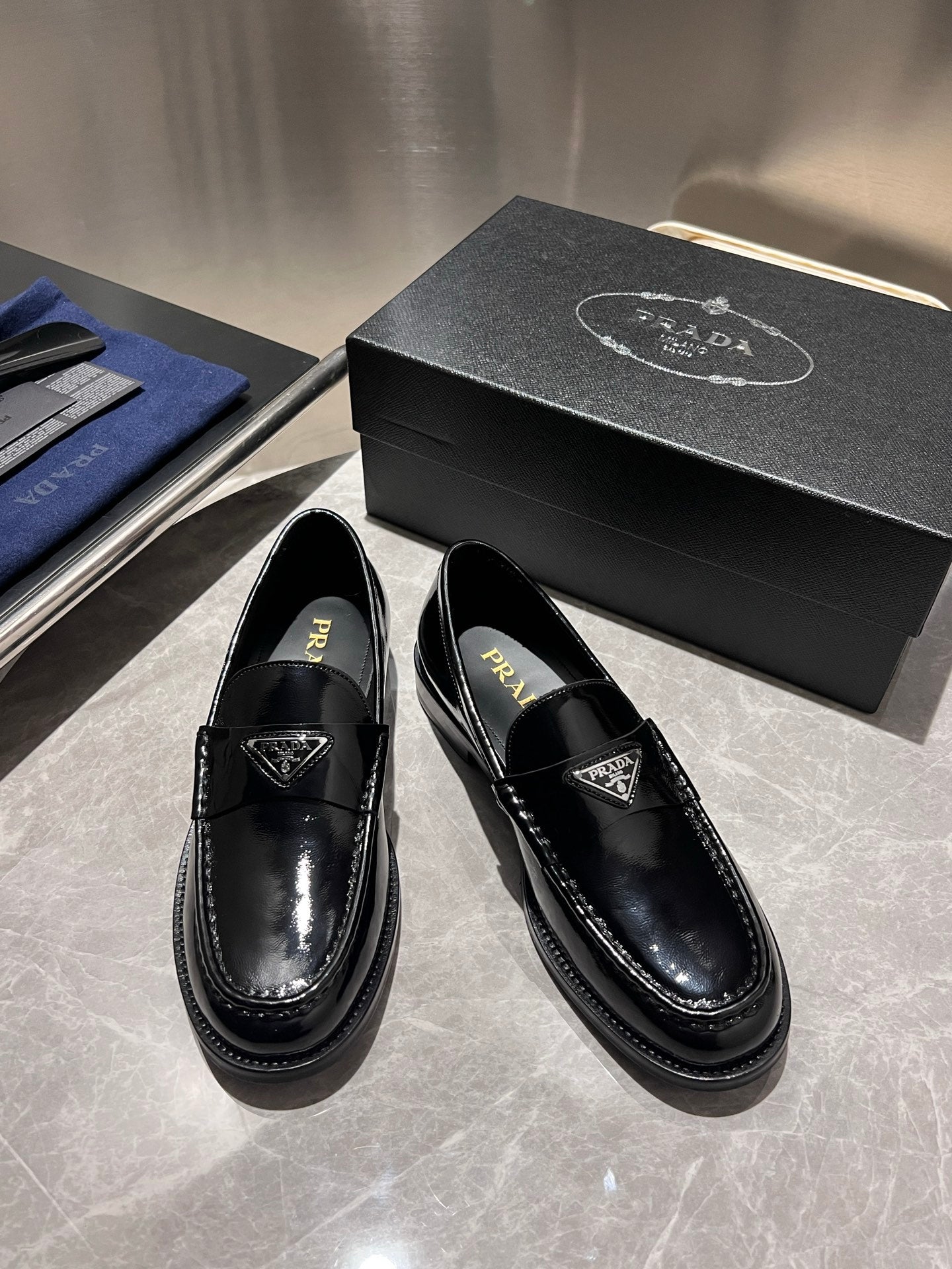 Prada unisex black patent loafers with Prada branding on insole