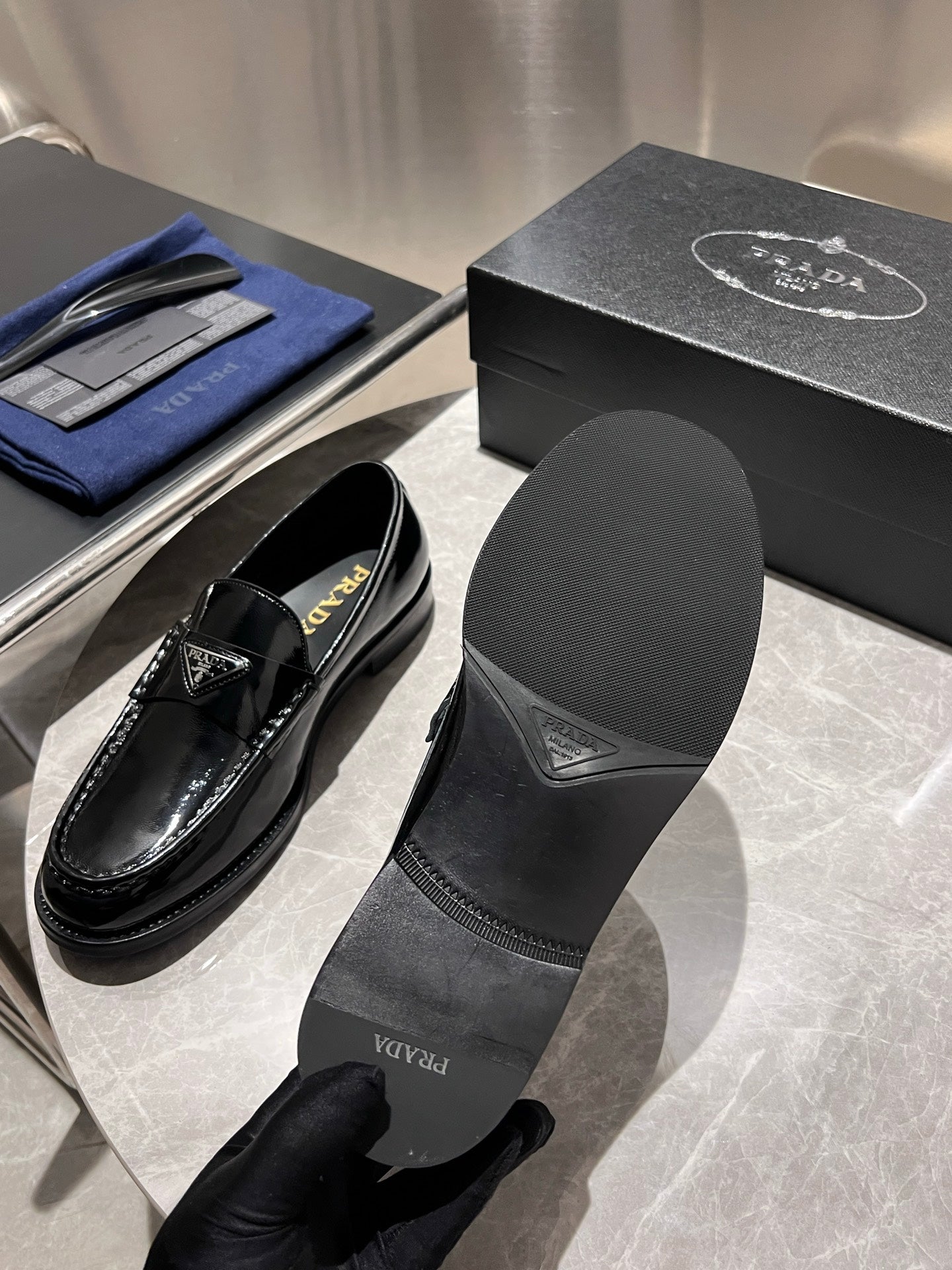 Prada unisex black patent loafers with matching insert labeled Prada