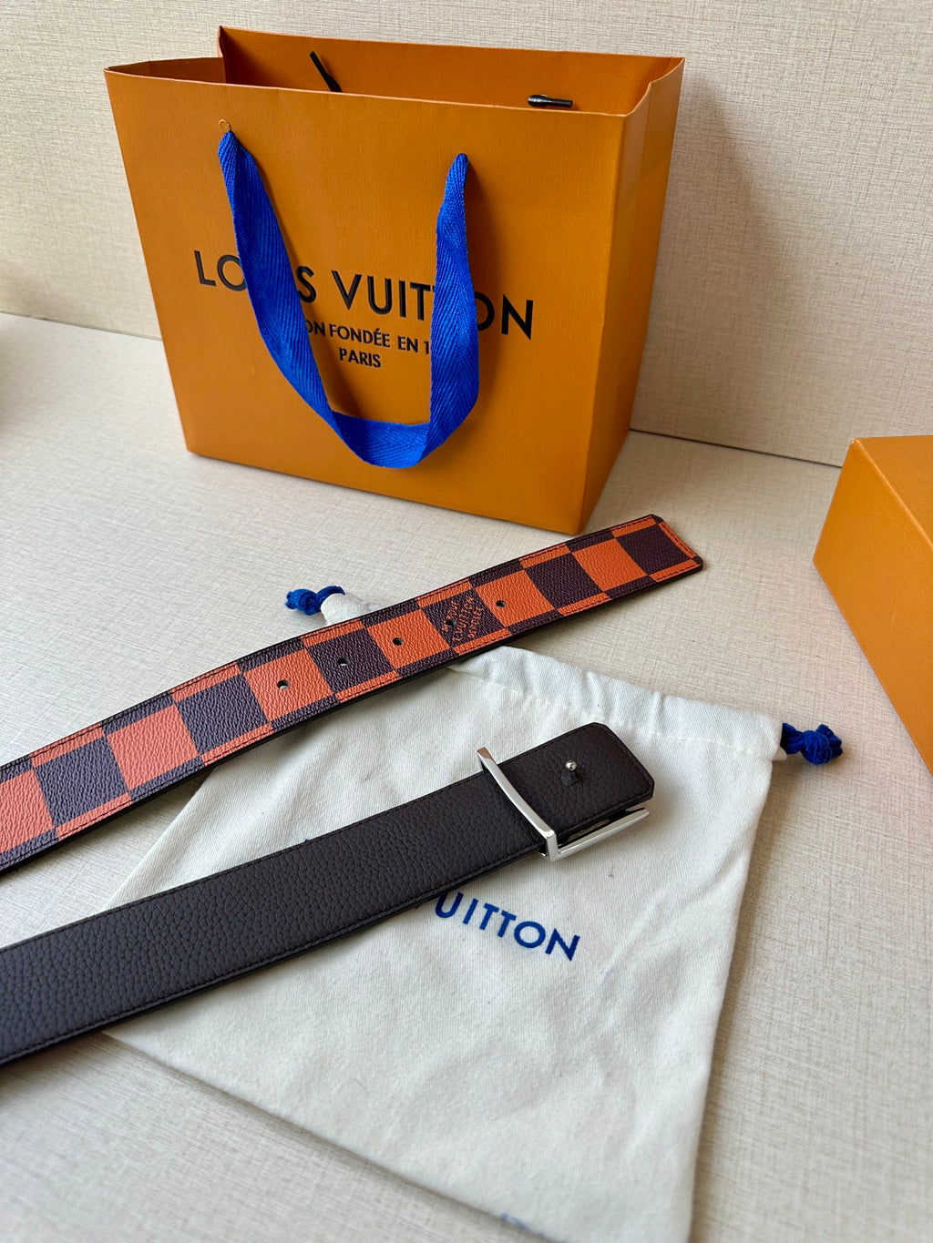 Louis Vuitton belt with orange-brown patterned strap and matching black backing, plus card case.