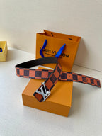 Louis Vuitton belt with orange-brown check strap and oversized LV buckle across packaging.