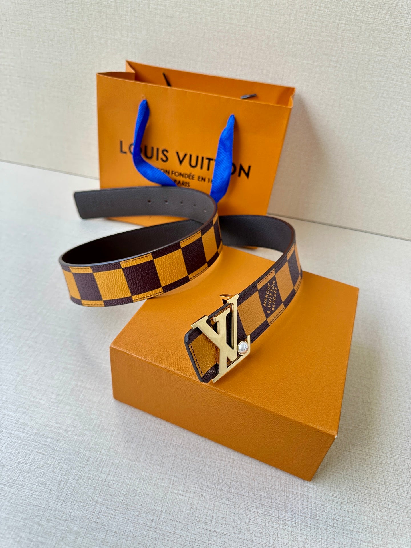 Check-pattern belt with gold-tone LV buckle and dark leather strap