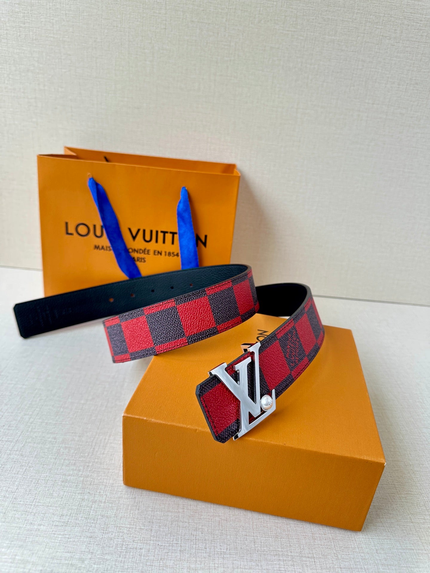 Louis Vuitton belt with red-and-black check canvas strap and silver LV buckle