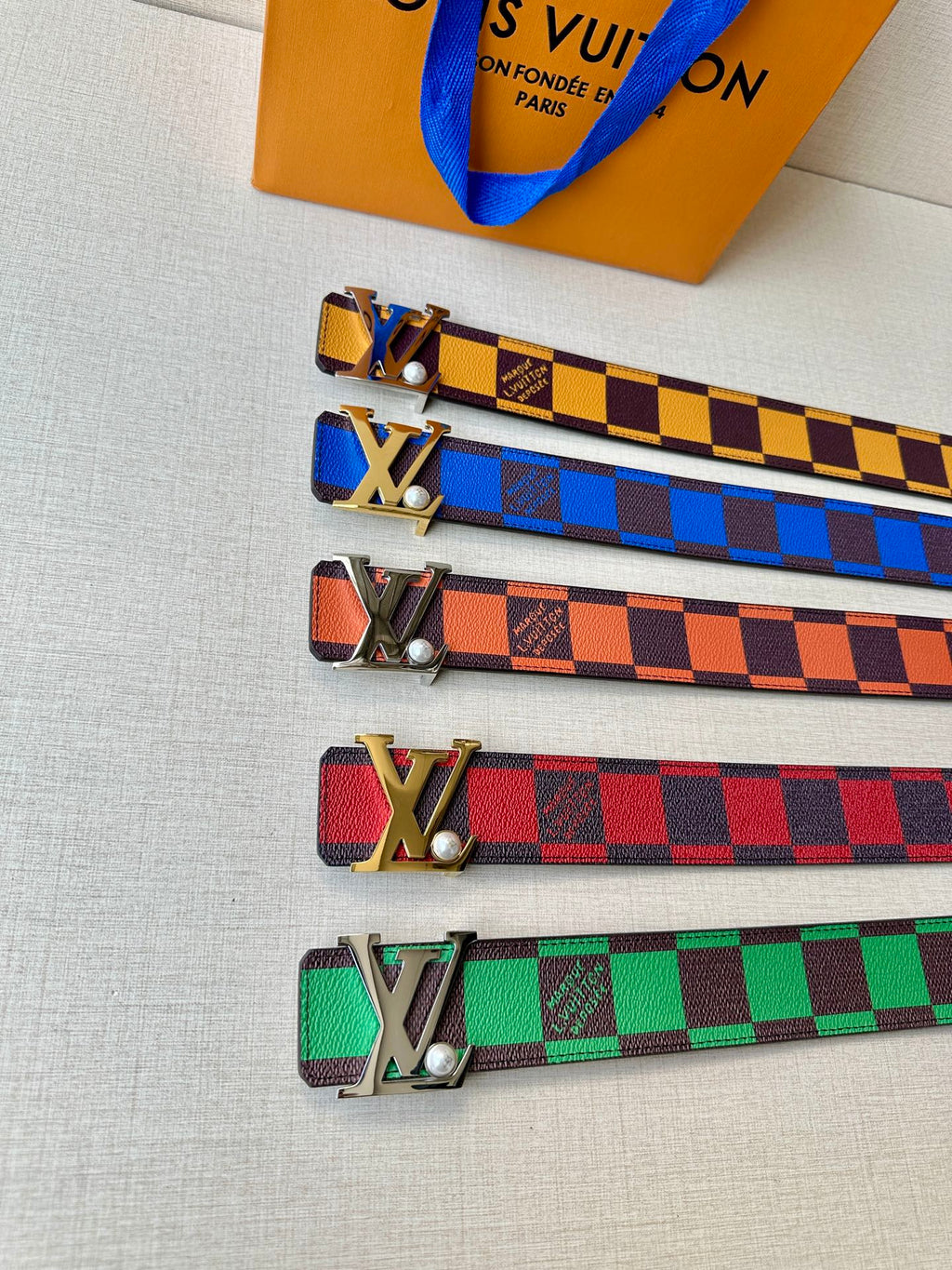 Set of Louis Vuitton belts in colorful checker patterns with metal LV buckles