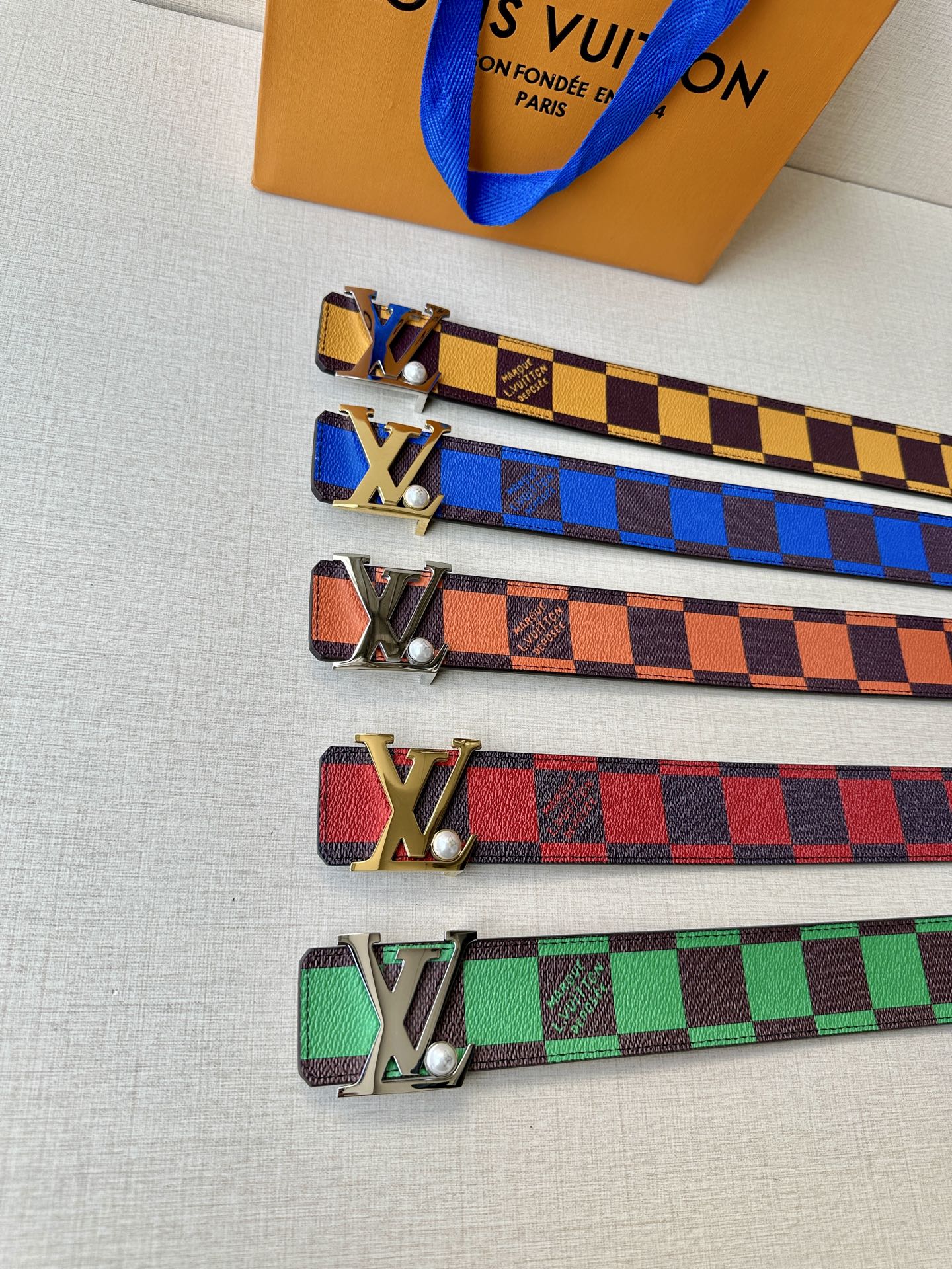 Set of Louis Vuitton belts in colorful checker patterns with metal LV buckles