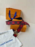 Louis Vuitton belt with red-and-black check strap, silver buckle, and attached end