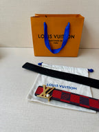Louis Vuitton belt with red-and-black check strap and silver LV buckle, with pouch