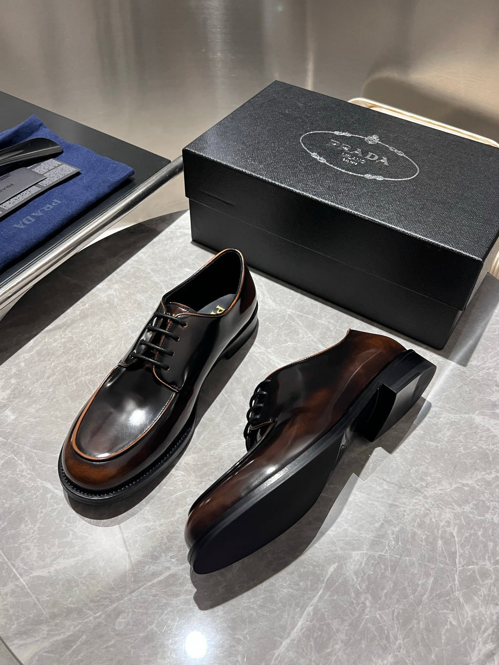 Brown leather lace-up shoes with black soles and stitched edge