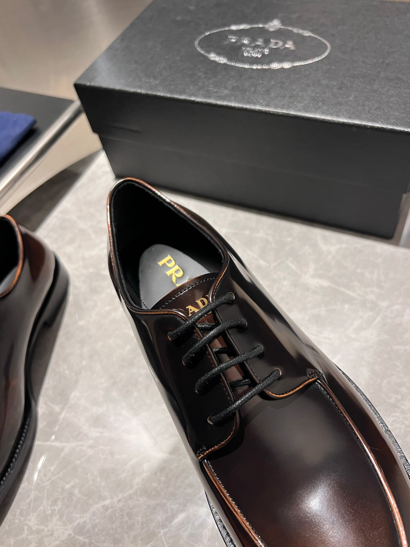 Brown leather lace-up shoe with black laces and logo-lined tongue
