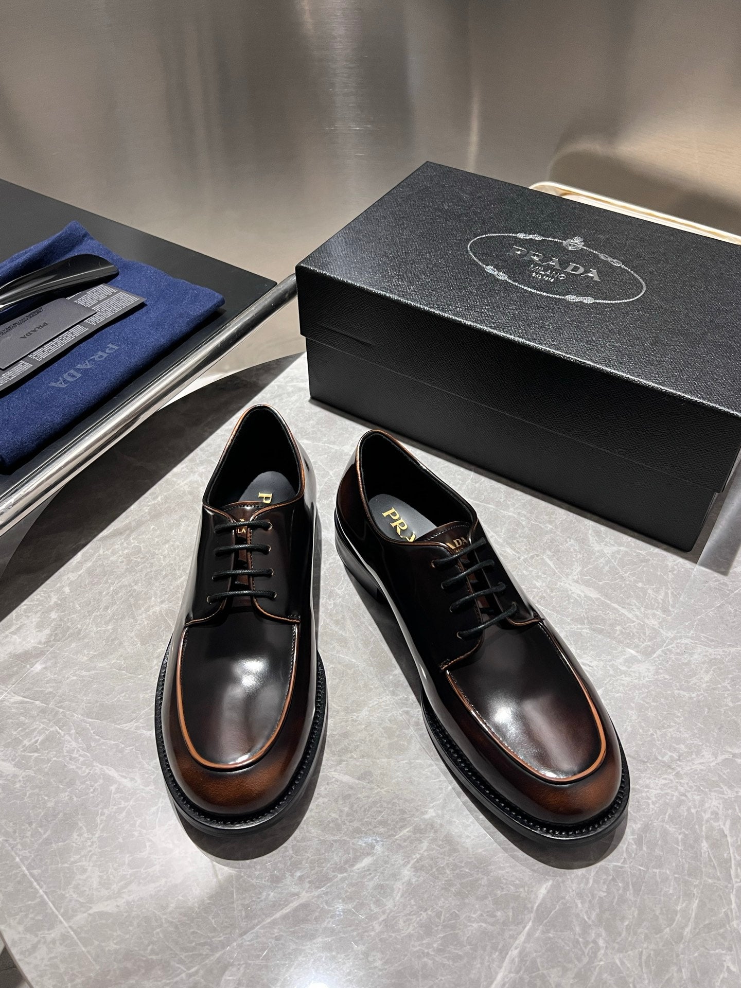 Black leather lace-up shoes with brown edge trim and glossy finish