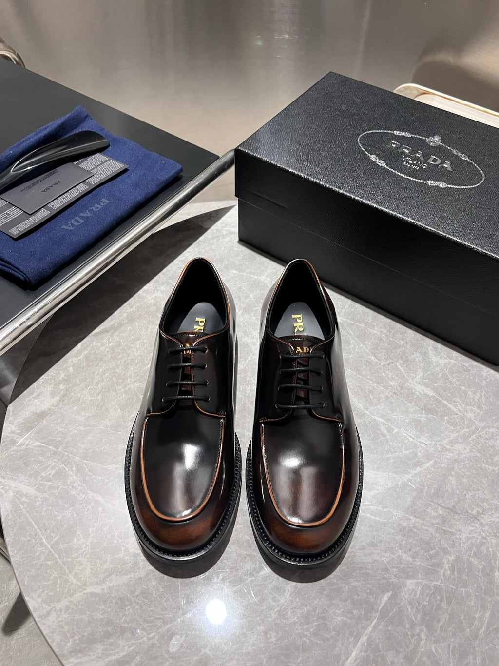Black leather lace-up shoes with brown-trim soles and lace-up front