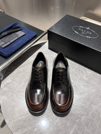 Black leather lace-up shoes with brown-trim soles and lace-up front