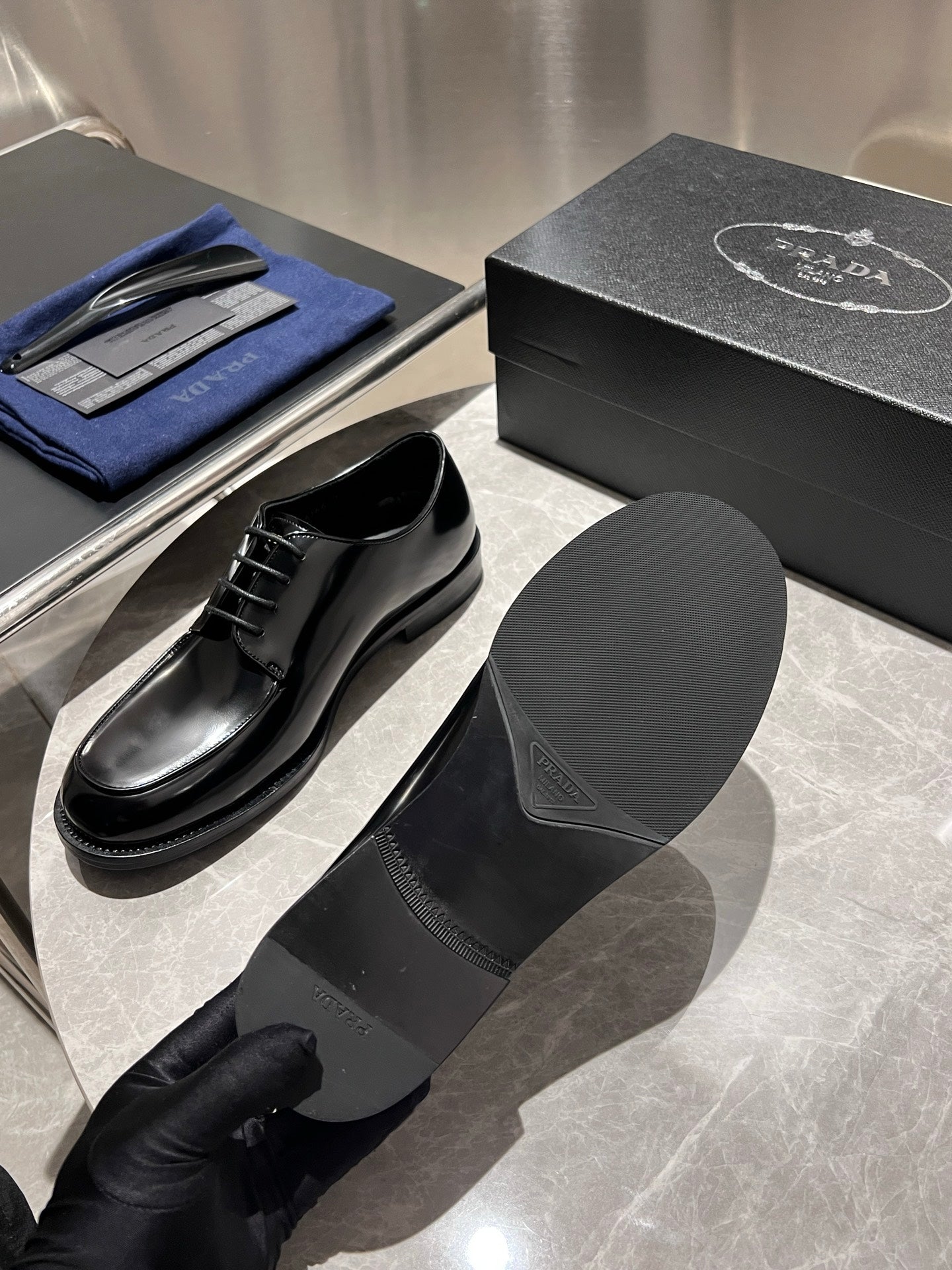 Unisex black leather lace-up shoes with outsole and insole view, plus shoe box