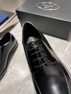 Unisex black leather lace-up shoes close-up, black laces and branded tongue