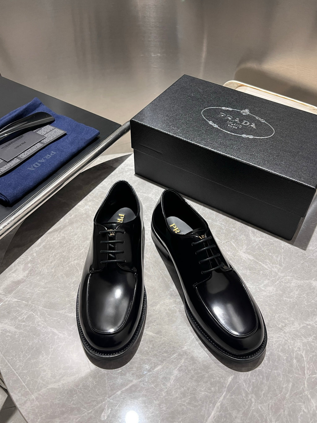 Unisex black leather lace-up oxford shoes, angled front view with black laces