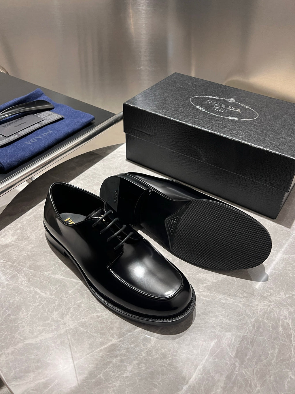 Unisex black leather lace-up shoes with box, one shoe top view and one side view