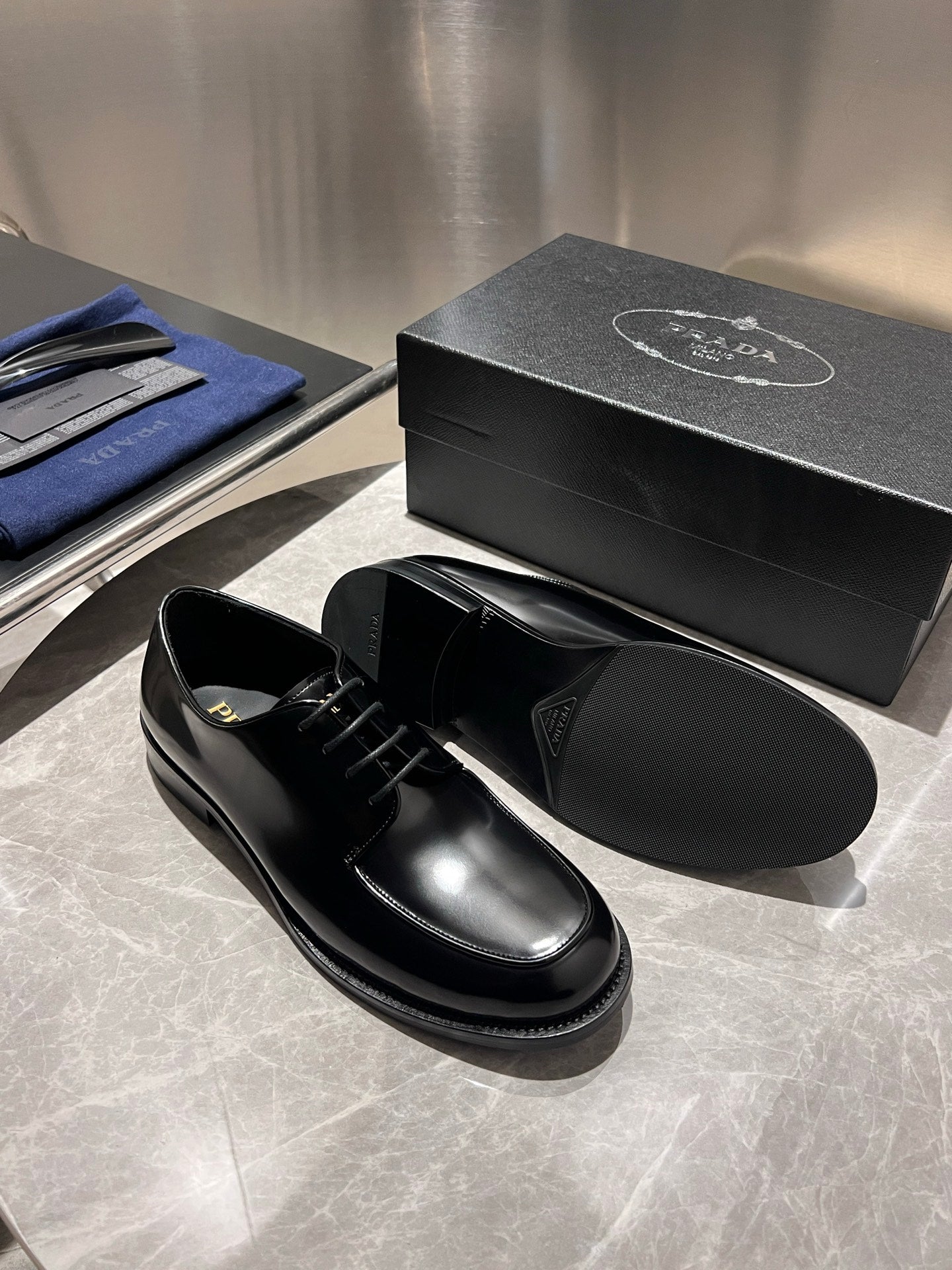 Unisex black leather lace-up shoes with box, one shoe top view and one side view