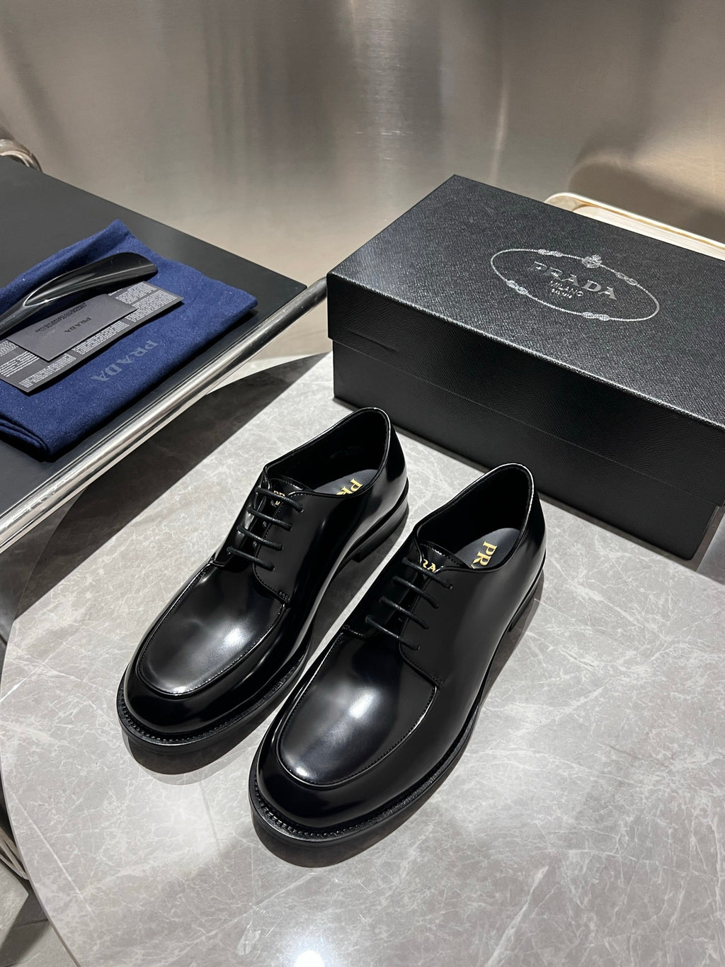 Unisex black leather lace-up oxford shoes, front view with black laces and rounded stitching