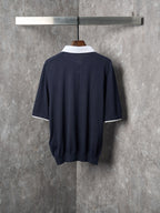 Navy polo shirt back view with white inner collar trim and short sleeves.