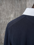Navy polo shirt shoulder with white collar edge and clean knit texture