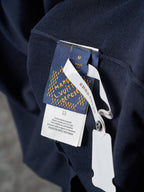 Navy polo shirt with attached hang tag and brand label on the sleeve
