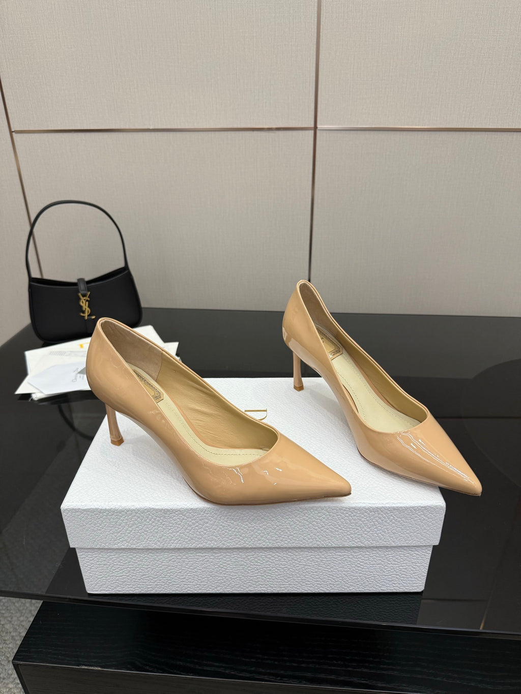 Beige patent pointed-toe pumps, side view, slender stiletto heels