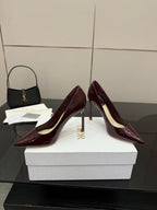 Burgundy patent leather pointed-toe stiletto pumps, front three-quarter view