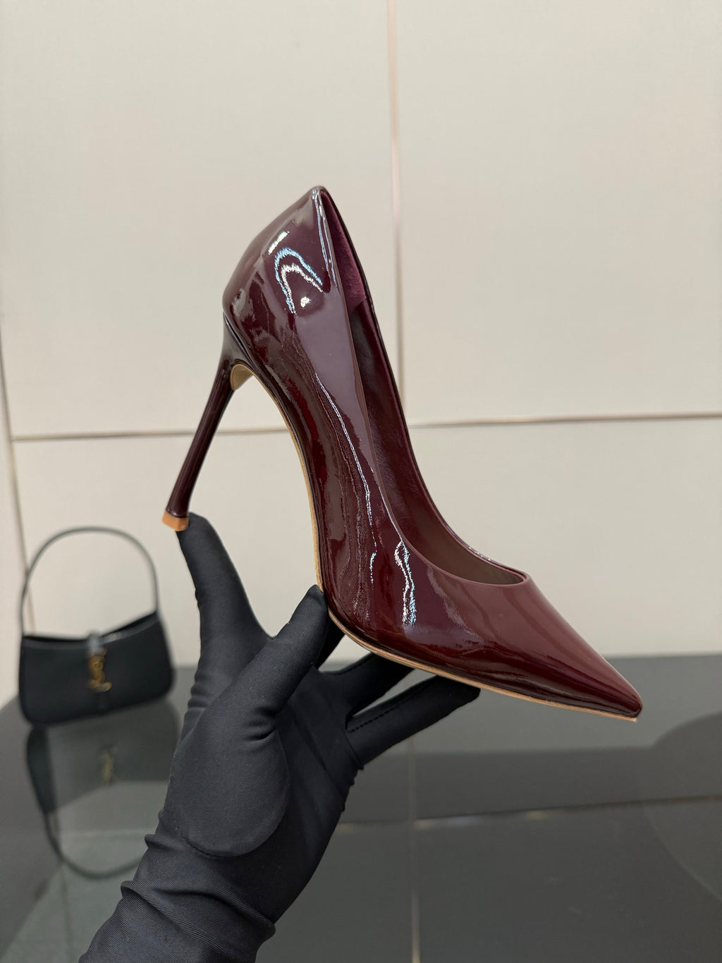 Burgundy patent leather pointed-toe stiletto pump, close-up of heel