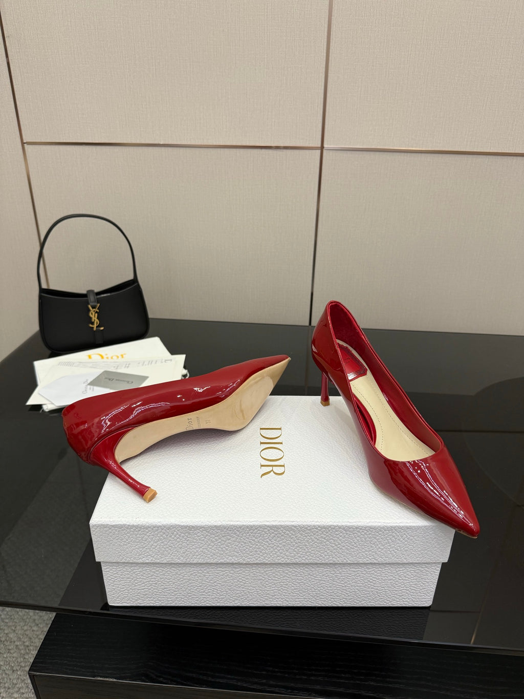 Red patent pointed-toe pumps with stiletto heels, heel and toe view on box