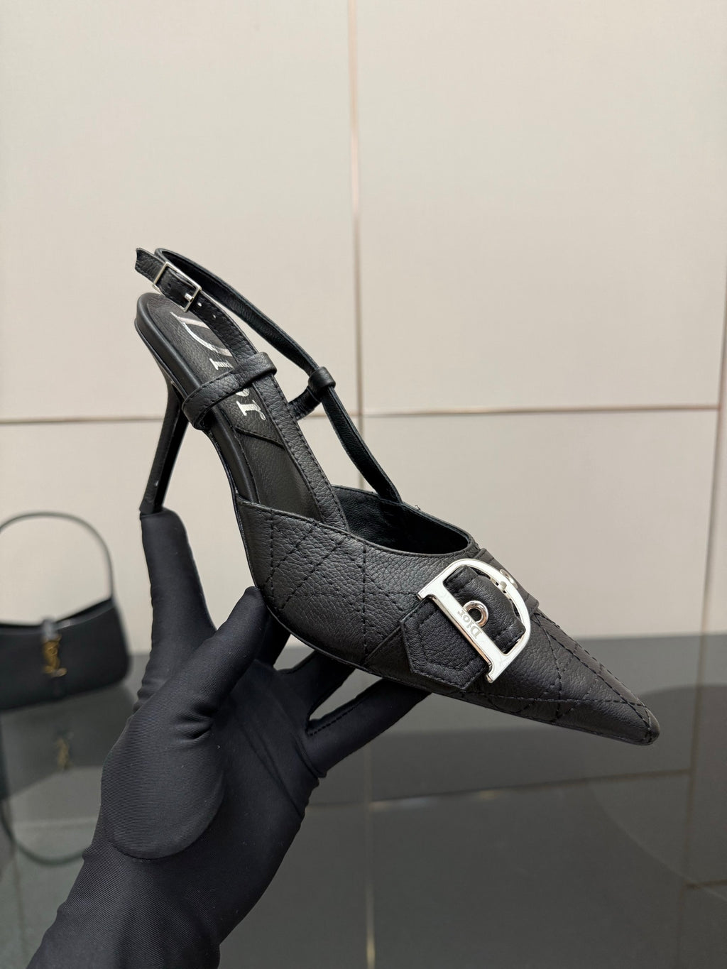 Black Dior slingback pump close-up, silver buckle strap, textured leather upper