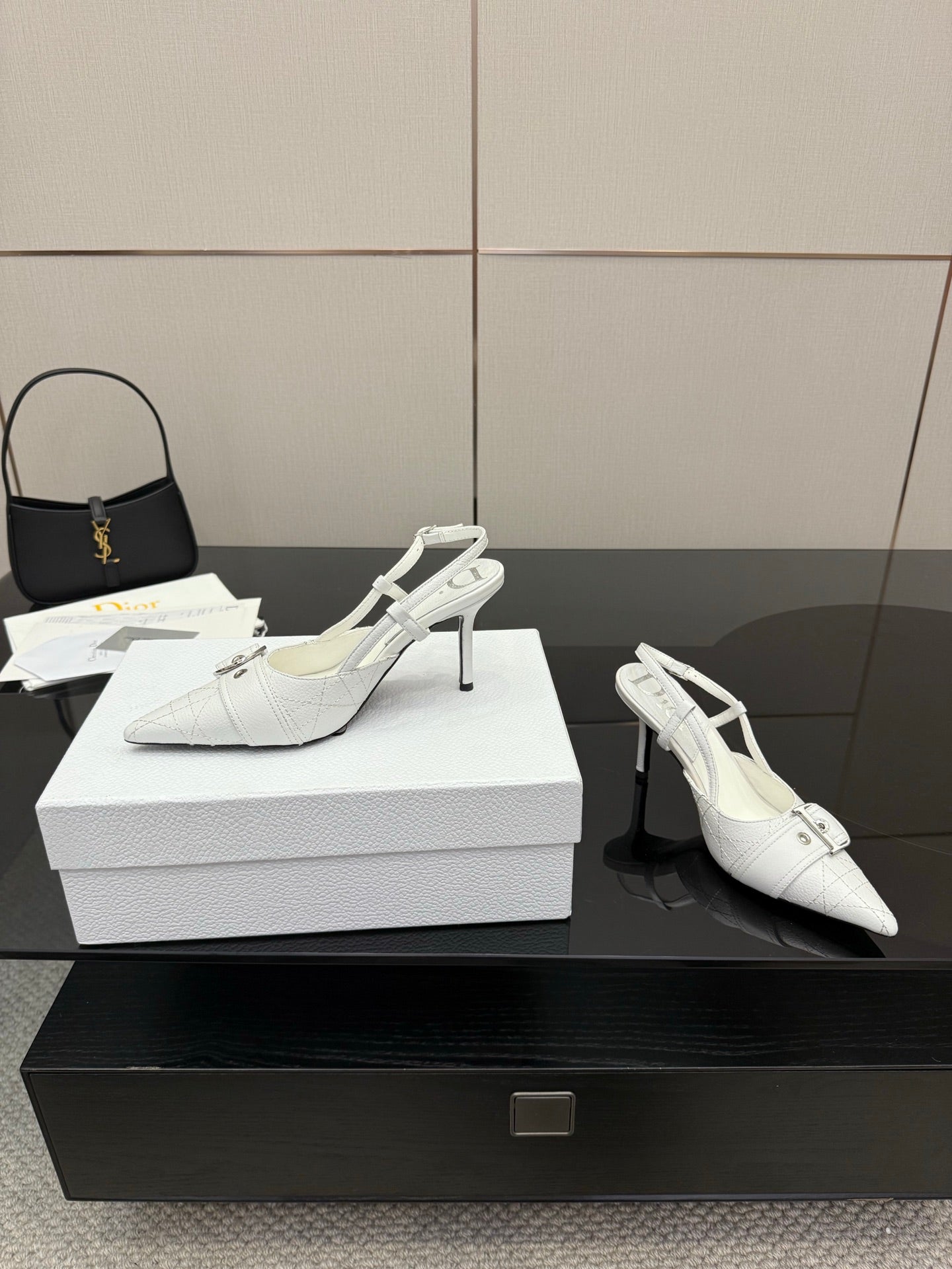 White slingback heels with pointed toe, ankle strap buckle, and slender stiletto heel