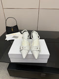 White pointed-toe slingback heels with buckled ankle strap and slim stiletto heel