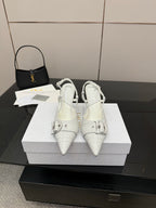 White pointed-toe slingback heels with buckled ankle strap and slim stiletto heel
