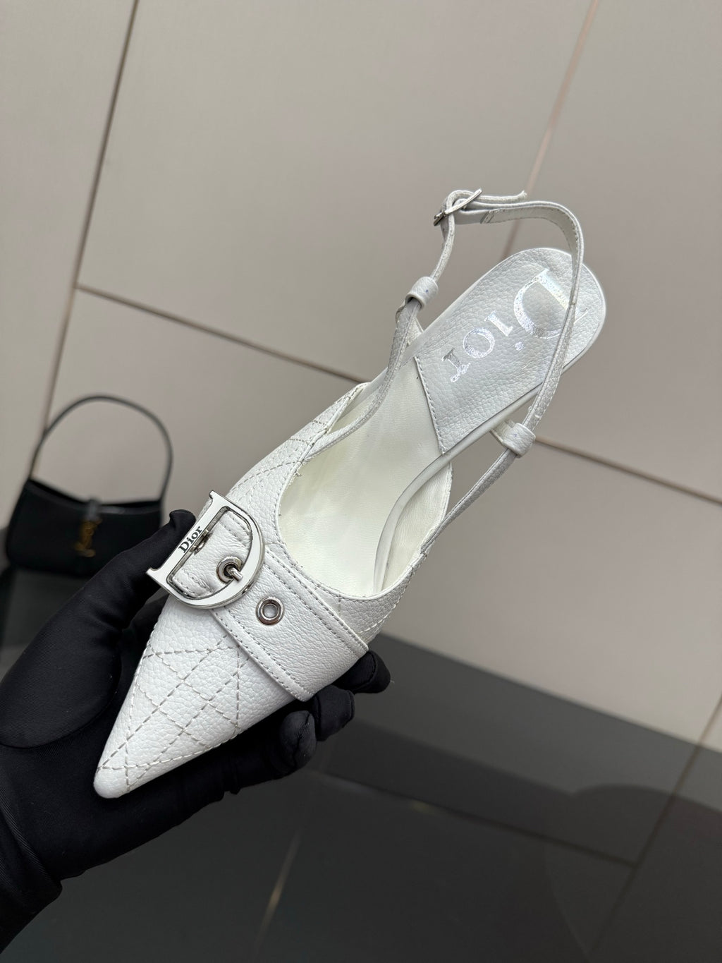 White slingback heel shoe with ankle strap buckle and pointed toe